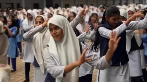 The photo shows Muslim girls at Thanbihul Islam Higher Secondary School in Kerala's Kasaragod district involved in a Zumba session
