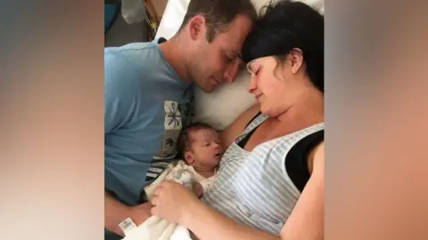 BBC Jonny and Jenna Veron hold their son Oliver in their arms