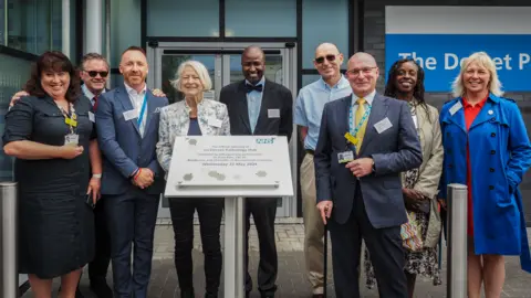 UHDNFT Kate Adie and NHS staff stand at entrance of new pathology centre