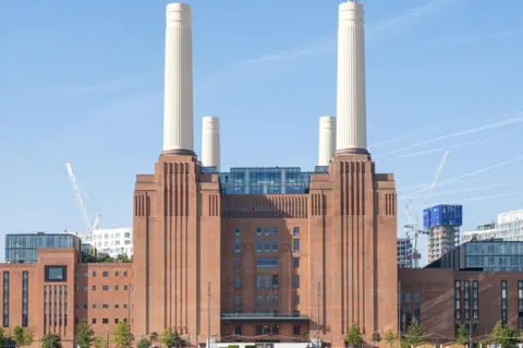 Battersea Power Station - a red brick building with four tall white chimneys
