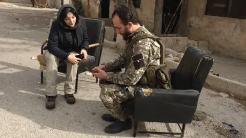 A man in military uniform is sitting next to a woman in civilian clothes