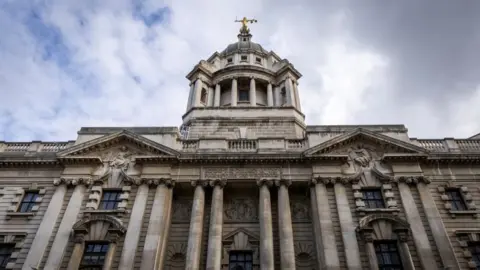 A gold statue of Lady Justice sits on top of the Central Criminal Court on the 11th of March 2025 in London, United Kingdom. The Central Criminal Court of England and Wales, commonly referred to as the Old Bailey after the street on which it stands, is a criminal court building in central London, one of several that house the Crown Court of England and Wales.