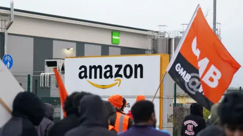 PA Media Amazon staff members on a GMB union picket line outside the retailer's site in Coventry