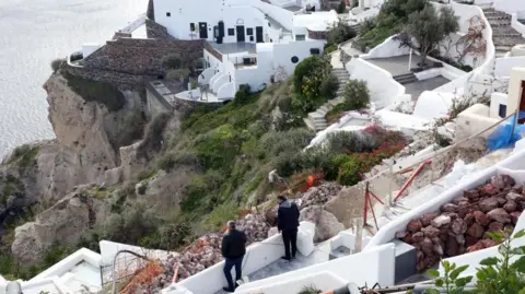 EPA People examine their property in the almost evacuated village of Oia on Santorini island, Greece, 05 February 2025