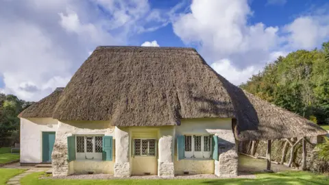 Historic England Archive General view of the Friends Meeting House from the south, showing its wheat reed thatched roof