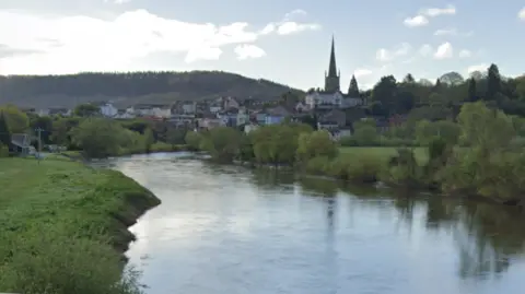 The view of the River Wye looking towards Ross-on-Wye, with the town and church in the background, and the river and its banks in the foreground