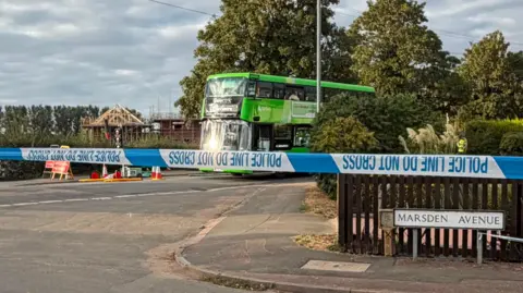 Leicester Media Online A green double decker bus behind a police cordon