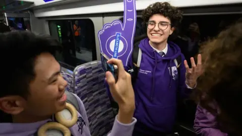 Rail and underground enthusiasts travel on the first eastbound train as the Elizabeth Line opens to the public at Paddington Station on May 24, 2022 in London, England. Originally due to open in December 2018, the £18.8bn railway links Reading and Essex via central London