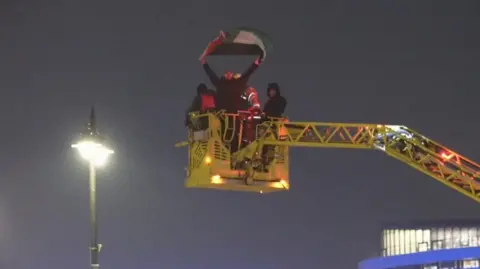 Man being taken down from tower 