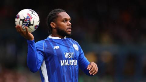 Mahlon Romeo in a Cardiff City shirt with a ball in his right hand