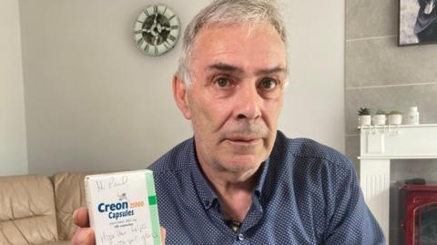 Paul Elcombe with a pack of the Creon capsules he needs to take