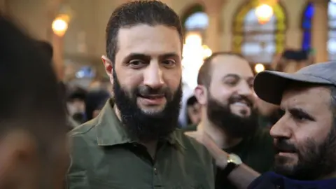 Getty Images Abu Mohammed al-Jolani addressing crowds in a mosque in Damascus