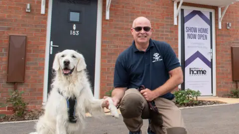 Phil James holding hands with a dog