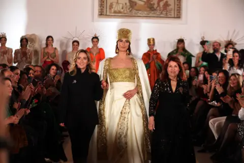 Mohamed Messara / EPA Tunisian designer Fatma Ben Abdellah (R) with her daughter Nour (L), who is also a designer, appear on stage during a fashion show.