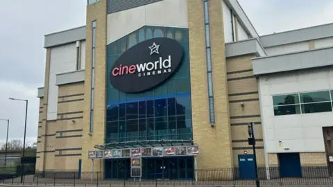 The exterior of Cineworld, with prominent branding to the front and upcoming film posters over the entrance