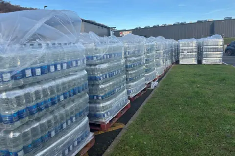 Lines of water are seen stacked on pallets 