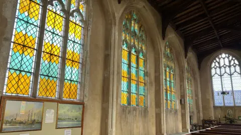 Immy Lee/BBC Four arched and leaded stained windows alongside the church, with one with clear glass at the end.