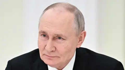 Reuters Big close-up of Vladimir Putin, wearing black jacket and white shirt