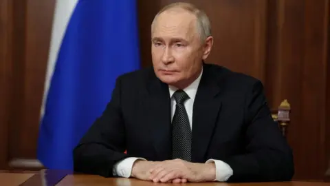 Reuters Presiden Rusia Vladimir Putin duduk di mejanya menyampaikan pidato kepada warga Rusia di TV