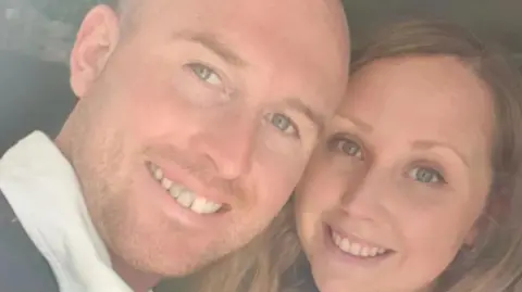SWNS A selfie of Josh and Hannah. Hannah has long light brown hair and Josh has a shaved head and short stubble.