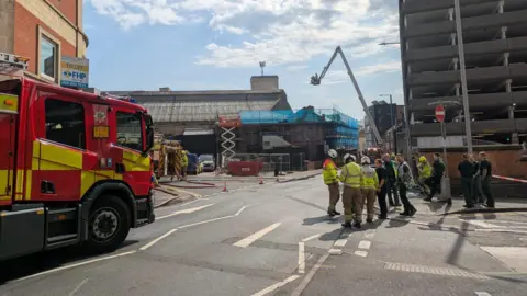 A fire engine and firefighters are stood in the road in Talbot Street.