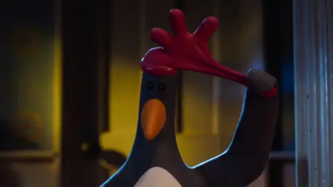 AARDMAN/BBC Feathers McGraw pulls a red rubber glove off his head.