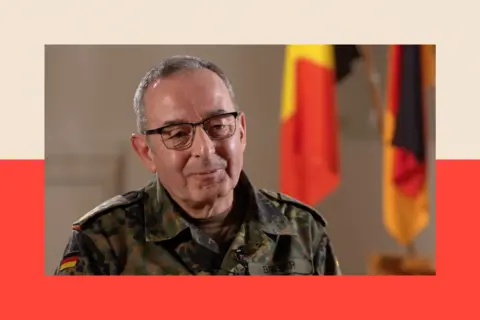 General Carsten Breuer wears glasses and a camouflage military jacket