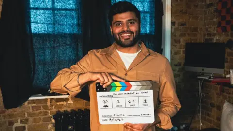 Callum Fernandes-Clarke Juggy Sohal holding a film clapper board