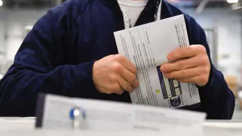 BBC An election worker demonstrating how ballots are received in Philadelphia, Pennsylvania. 