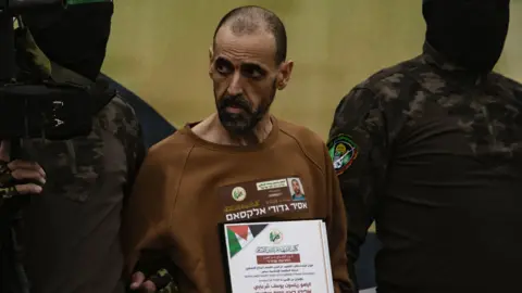 epa eli sharabi stood between two Hamas soldiers looking thin