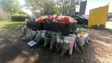 Flowers left at the site as tribute to the three victims.