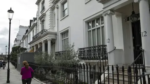 The Knightsbridge house seized by the NCA, a white house with balconies at their windows and steps to the front door.