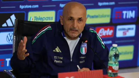 Luciano Spalletti sat at a desk during a news conference