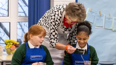 PA Media Dame Prue Leith joins Year 1 and 2 pupils at St Clement & St James Primary School in West London for a cookery lesson, as she announces a new nationwide commitment from Leiths to teach every primary-age child in Britain how to cook.