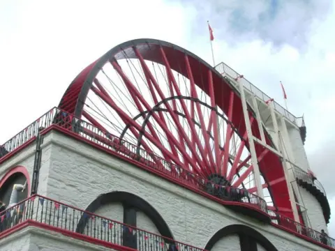 S Murray The Great Laxey Wheel. the largest water wheel in the world , with large red spokes 