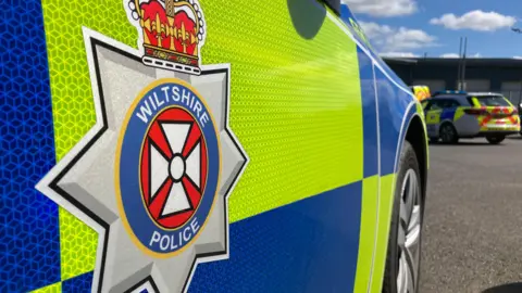 BBC Generic photo of the side of a Wiltshire Police car - close-up of the side, showing the logo.