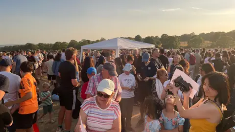 Dan Bater/BBC Crowds gathered around a white marquee in Roundhay Park.