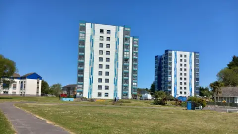 Catherine Multiple blocks of flats with grass areas outside.