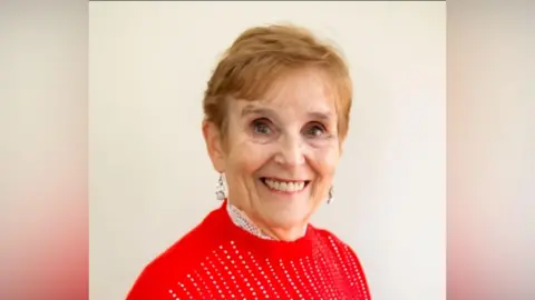 Supplied An elderly woman in a red jumper. 