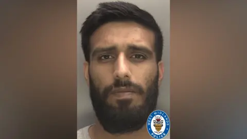 West Midlands Police A mugshot of a man with dark brown hair styled to one side, brown eyes, and a dark brown beard and moustache. It has a West Midlands Police badge in one corner.