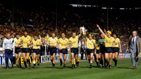 Mark Leech/Offside via Getty Images The Oxford team parade the trophy around the pitch following their victory against QPR in April 1986.
