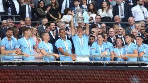 Manchester City players lift the FA Cup trophy