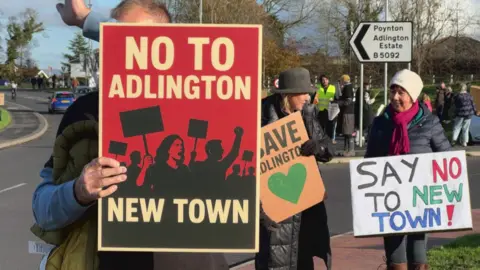 Protesters holding signs saying no to the Adlington new town