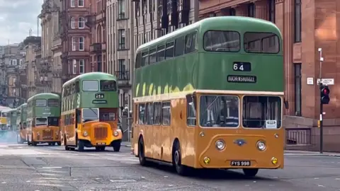 Vintage bus parade on Glasgow city centre street