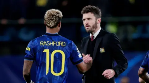 Michael Carrick greets Marcus Rashford