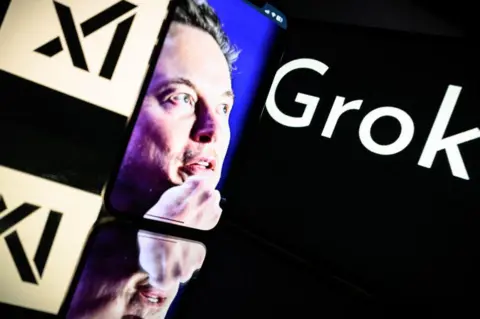 AFP This photograph taken on January 13, 2025 in Toulouse shows screens displaying the logo of Grok, a generative artificial intelligence chatbot developed by xAI, the American company specializing in artificial intelligence and it's founder South African businessman Elon Musk.