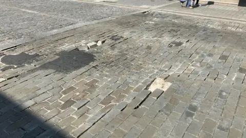 Henry Godfrey-Evans/BBC A damaged section of road in Brentwood town centre