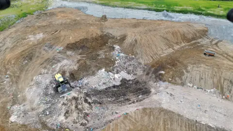 Environment Agency - South and South West An aerial image of a brown dirt area and a digger rolling on top of it.
