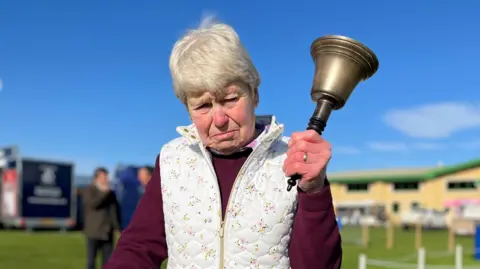 Liz Lang ringing the bell