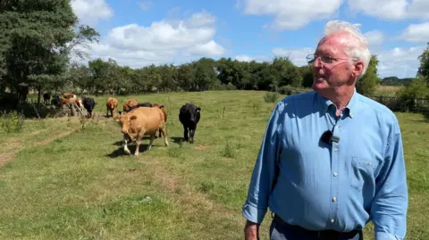 Graham on his farm, Low Swainby, herding the cows.
